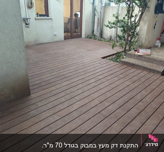רצפת דק עץ בחצר עם צמחייה בצד